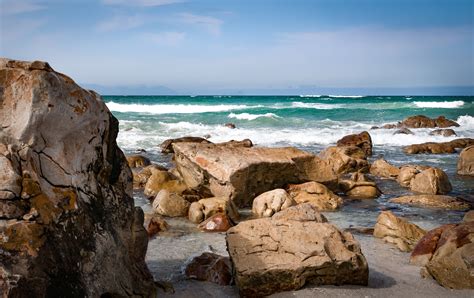 Seashore With Rocks Under Blue Sky · Free Stock Photo