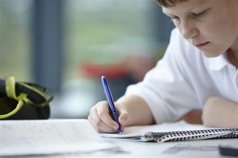 Close Up Of Schoolboy Writing In Class Geek School Tutoring 11 Plus