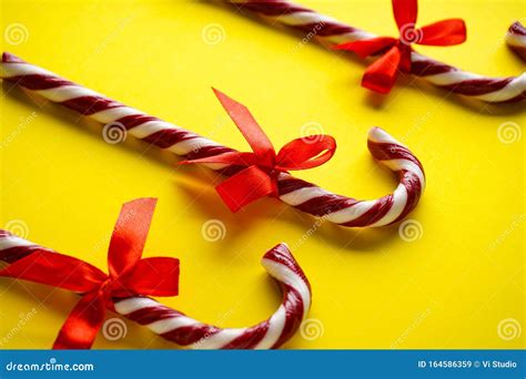 Christmas Concept Christmas Candies Cane With A Red Bow On A Yellow
