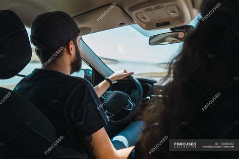 Rear View Of Man Driving Car With Passenger Sitting N — Sunlight