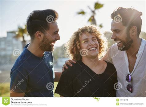 Three Male Friends Standing Together Outside Laughing Stock Photo