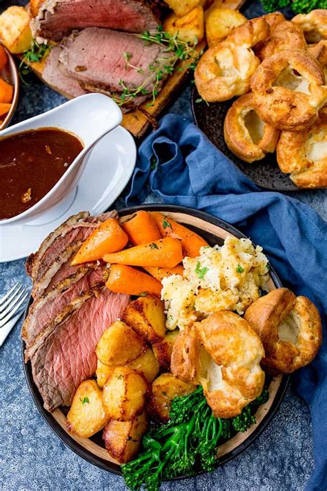 Roast Beef Potatoes And Carrots On A Plate With Gravy In The Background