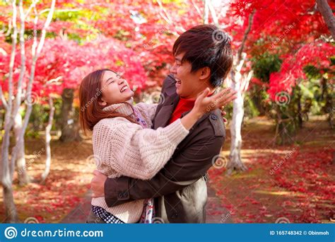Happy Couple In Autumn Park Beautiful Woman Gives A Big