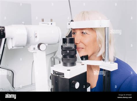 Senior Woman Receiving Eye Exam At Clinic Eyesight Examination Old