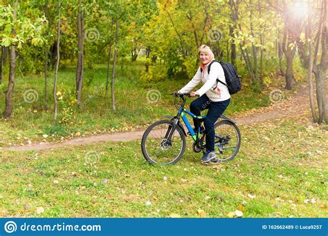 A Woman On A Bicycle Rides On The Road In The City Park Stock Image Image Of Healthy Activity