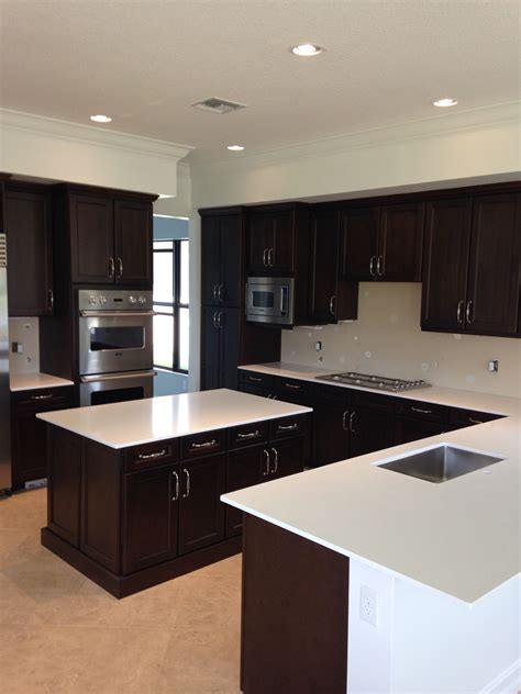 Check out this guide to the types of granite counter. White Quartz countertops and brown dark cabinets. http ...