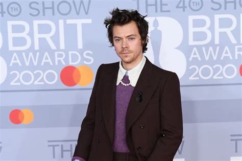Harry Styles Arrives At BRIT Awards Wearing Black Ribbon After Caroline