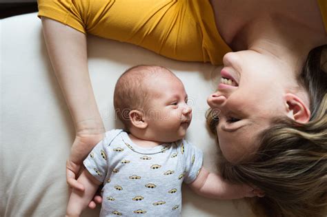 Madre Con Su Hijo Recién Nacido Del Bebé Que Miente En Cama Imagen De
