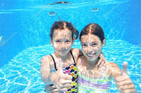 Happy Children Swim In Pool Underwater Girls Swimming Playing And