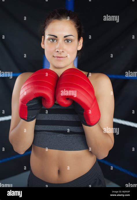 Portrait Of A Beautiful Young Woman In Red Boxing Gloves In The Ring