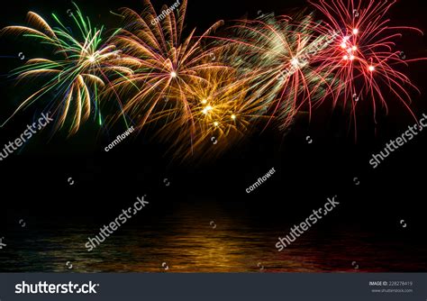Fireworks In The Night Sky Reflected In Water Stock Photo 228278419