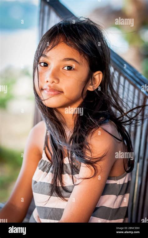 une jolie fillette philippine sourit sur la plage de las cabanas el nido philippines photo