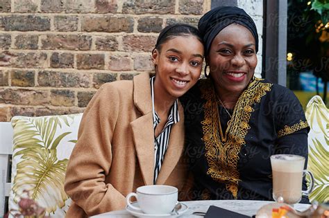 Smiling Muslim Mom And Daughter Having Coffee By Stocksy Contributor