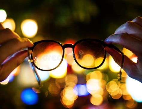Closeup Of Hands Holding Eyeglasses With Blurred Bokeh Lights Ba Stock