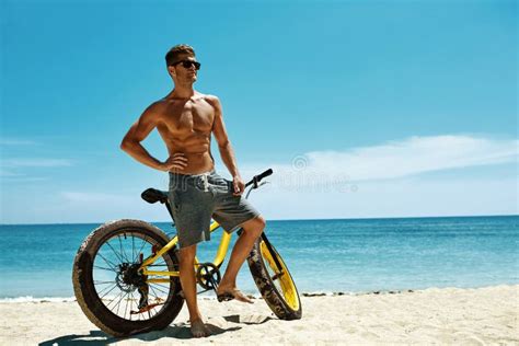 Handsome Man With Bike Sun Tanning On Beach Summer Vacation Stock