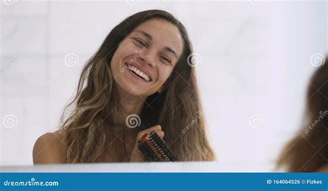 Happy Beautiful Young Woman Brushing Long Hair Looking In Mirror Stock