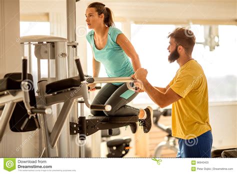 Gymwoman Exercise Muscles With Assisting Her Personal Trainer Stock