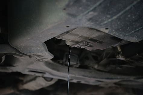 Old And Dirty Engine Oil Being Drained From Underneath A Car During An