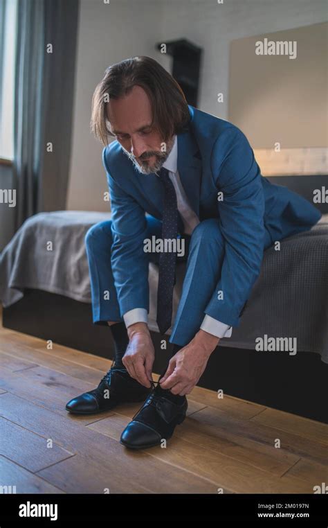 Putting On Shoes Man In Blue Suit Putting On His Shoes Wile Sitting On