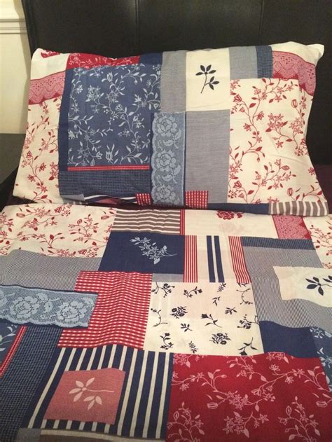 A Bed Covered In Red White And Blue Quilts