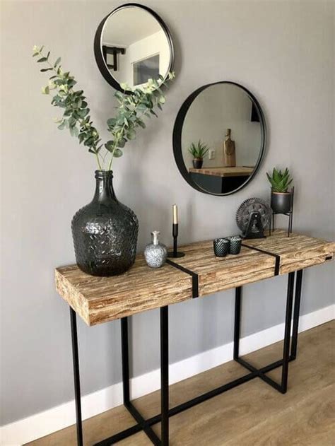 A Wooden Table Topped With A Vase Filled With Flowers Next To A Mirror