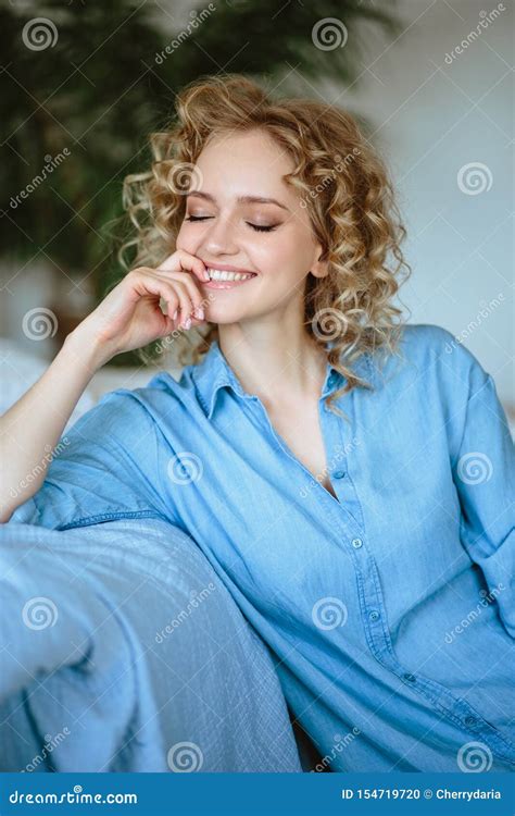 Pretty Cheerful Blonde Young Woman With Curly Hair And Charming Smile