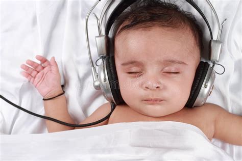 Bebé Que Escucha La Música Con Los Auriculares Imagen De Archivo