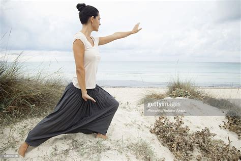 Woman Practicing Tai Chi Chuan On Beach Side View Photo Getty Images
