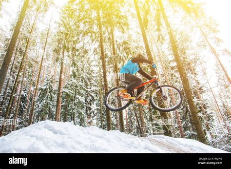 Silhouette Of A Cyclist In A Jump Mountain Biking On Trails In A Snowy
