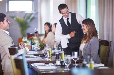 Business People Placing An Order With Waiter At Hotel Restaurant Stock