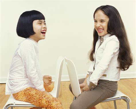 Foto Gratis Two Young Girls Sit Face To Face On Chairs Giggling Para Descargar Freeimages