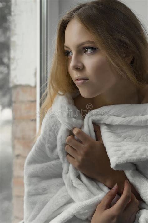Girl Looking Out The Window Wrapped In A Cozy Blanket Stock Image