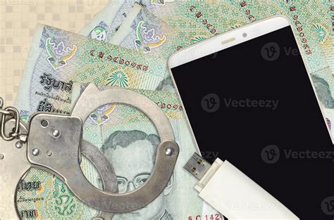 20 thai baht bills and smartphone with police handcuffs concept of hackers phishing attacks