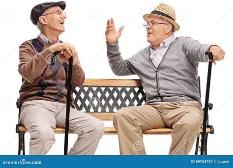 Two Retired Elderly People Sitting On A Bench And Laughing Stock Image