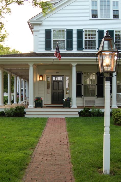 Traditional White House With Black Shutters And Big Front Porch On