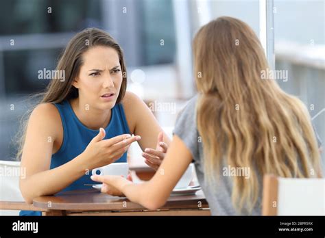 Two Angry Girls Talking Seriously Sitting In A Coffee Shop Stock Photo