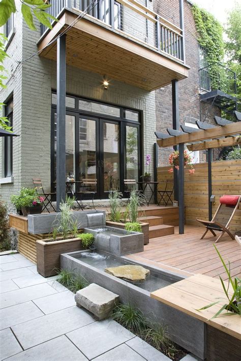 An Outdoor Patio With Water Feature And Seating Area Surrounded By Wooden Decking Areas