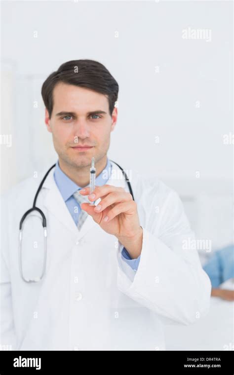 Handsome Male Doctor Holding An Injection Stock Photo Alamy