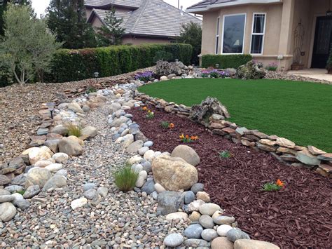 Dry landscaping is often equated with creating a desert look. Drought tolerant landscape. Dry creek bed, artificial turf ...