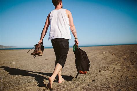 A Man Walks Along Beach Del Colaborador De Stocksy Howl Stocksy
