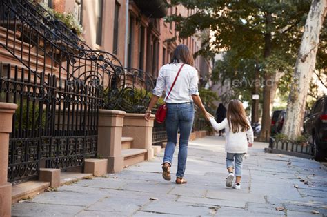 Mother And Daughter Walking Down The Street Back View Stock Photo By