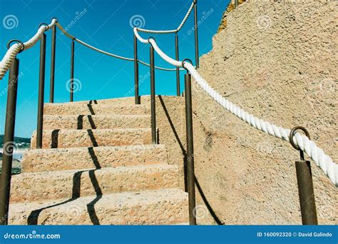 Wooden Ladder With Rope Railings On Cliff By The Ocean Stock Photo
