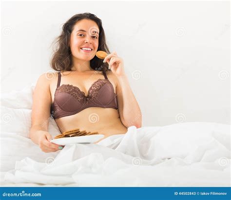 Dziewczyny łasowania Ciastka W łóżku Obraz Stock Obraz złożonej z ukradkowy brunetka