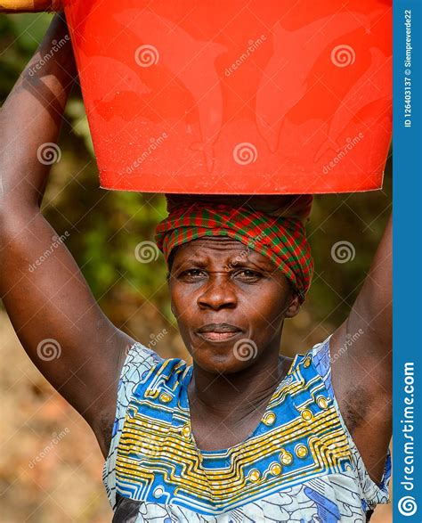 unidentified local woman carries a basin on her head in a villa editorial photography image of