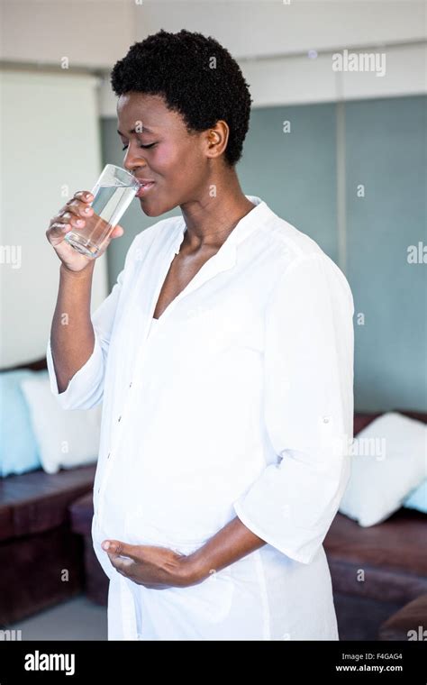 Pregnant Woman Drinking Water While Standing Stock Photo Alamy
