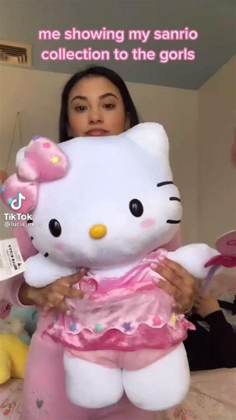 A Woman Holding A Large Hello Kitty Stuffed Animal In Her Arms With The