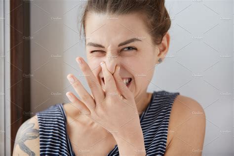 Close Up Shot Of Caucasian Girl Showing Disgust Pinching Her Nose To