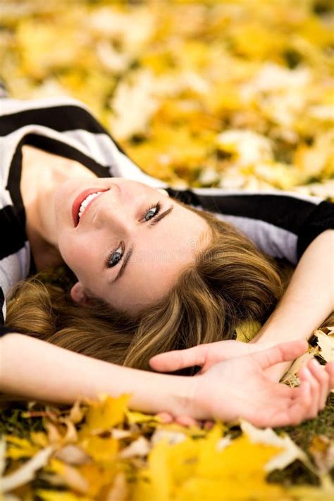 A Young Woman Lying On The Ground Looking At An Autumn Leaf Stock Image Image Of Caucasian