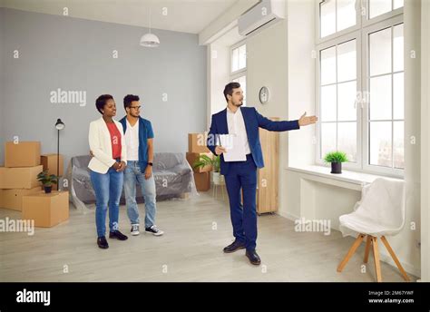 Man Realtor Show House To Multiethnic Couple Clients Stock Photo Alamy