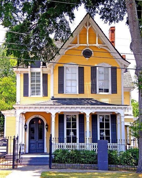 A Yellow House With Black Shutters And White Trim